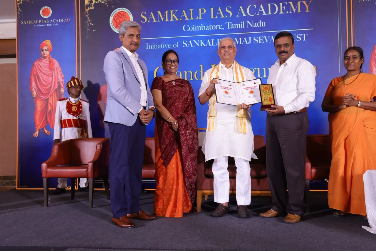 Honourable Dr. Rajendra Vishwanath Arlekar, Governor of Tamil Nadu, holding the signed MoU between Samkalp IAS Academy and Ramakrishna Arts and Science College, Coimbatore, on the inauguration stage.