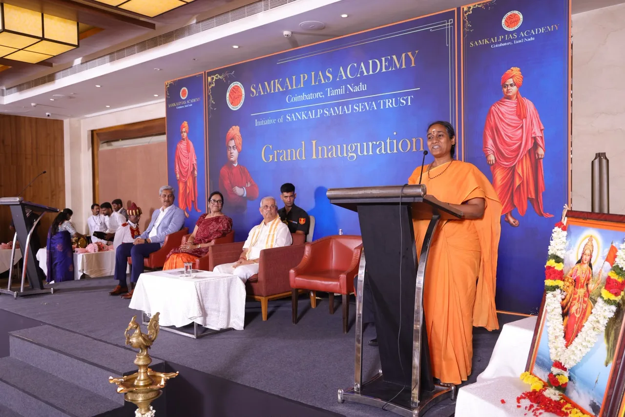Swamini Sampratishthananda of Chinmaya Gardens addressing the gathering at the podium with dignitaries on stage.